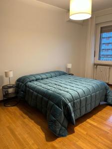 a bedroom with a large bed with a green blanket at A Casa di Simo in Turin