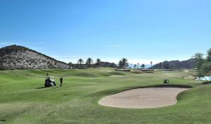 a couple of people standing on a golf course at El Sueño in San Juan de los Terreros