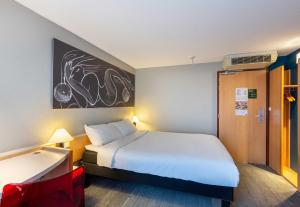 a bedroom with a large white bed in a room at B&B HOTEL Orléans Centre Foch in Orléans