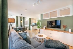 a living room with a couch and a tv at Stadtapartments Luna by Cosy Homes in Villach +54 photos