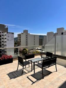 a patio with a table and chairs on a roof at Augusto Apart 4 in Salta