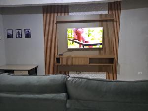 a living room with a couch and a flat screen tv at Casa Grande na zona sul in Sao Paulo