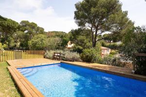a swimming pool in a yard with a wooden deck at Tamariu - Beautiful Villa with Pool in Palafrugell