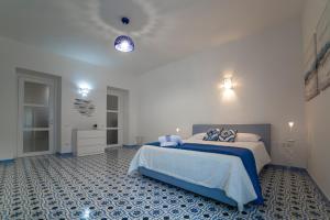a bedroom with a large bed with a blue floor at Le Due Sorelle in Vietri sul Mare