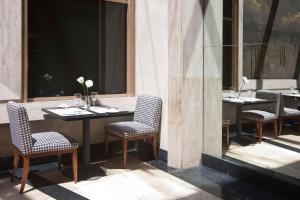 a restaurant with two tables and chairs and a window at NH Córdoba Urbano in Córdoba