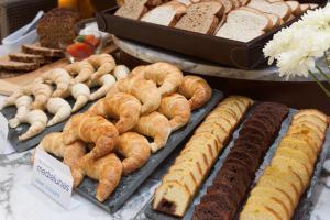 a display of different types of bread and pastries at NH Córdoba Urbano in Córdoba