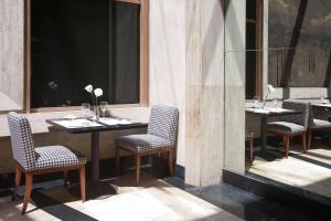 a restaurant with two tables and chairs and a window at NH Córdoba Urbano in Córdoba