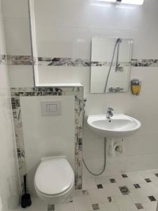 a bathroom with a white toilet and a sink at Sonne Hotel in Herne