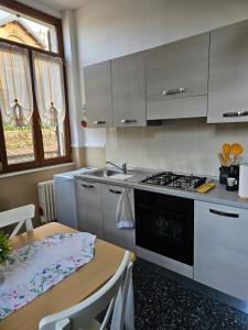 a kitchen with a stove and a sink and a table at Vista Lago in Luino