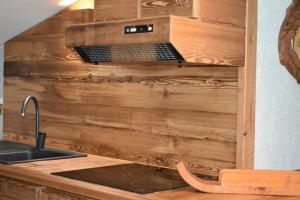 a kitchen counter with a laptop in a wooden wall at Monica's apartment Mansarda - Stella Alpina in Sauze dʼOulx