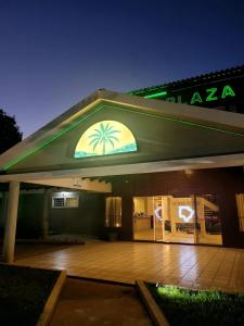 a building with a sign with a palm tree on it at Fênix Plaza Hotel in Aquidauana