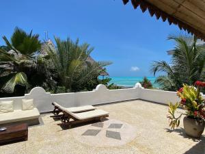 a patio with a view of the ocean at Mwendawima Beach Villa in Jambiani