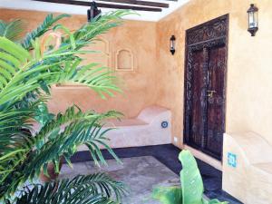 a room with a wooden door and some plants at Mwendawima Beach Villa in Jambiani