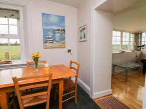 a dining room and living room with a table and chairs at The Well House Apartment in Watchet