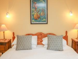 a bedroom with a white bed with two pillows at The Well House Apartment in Watchet