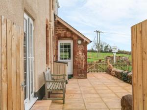 a patio with a bench next to a building at The Well House Apartment in Watchet