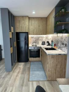 a kitchen with wooden cabinets and a black refrigerator at July apartaments in Velingrad +11 photos