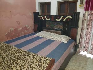 PrayagrajSarkar Homestay的一间卧室配有一张带猎豹纹床罩的床 更多8张照片