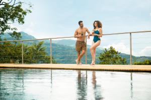 a man and a woman standing on the edge of a swimming pool at GreenOriental Resort in La Vega