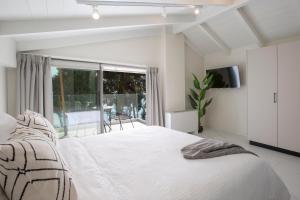 Un dormitorio blanco con una cama y una ventana grande. en Ionian Elite Beachfront Villa, en Nydri 41 fotos más