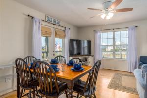 a dining room with a table with chairs and a ceiling fan at Beachy Keen in Dauphin Island