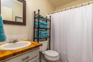 a bathroom with a sink and a toilet and a mirror at Beachy Keen in Dauphin Island
