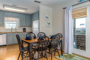 a kitchen with a table and chairs and a kitchen with a refrigerator at Beachy Keen in Dauphin Island