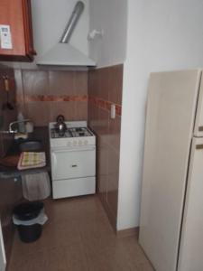 a small kitchen with a stove and a refrigerator at Casas Ña Zuna depto 6 in Concepción del Uruguay