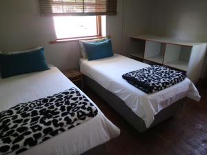 two beds in a small room with at Hostel Villa Nova in Mossel Bay