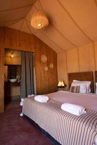 a bedroom with two beds in a tent at Erg Chigaga Torza Luxury Camp - Desert Glamping in El Gouera