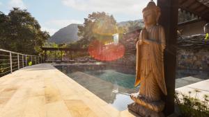 a statue sitting next to a swimming pool with aitating at GreenOriental Resort in La Vega