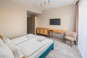 ein Hotelzimmer mit zwei Betten und einem Schreibtisch in der Unterkunft Hotel Atlantis Wellness & Conference in Hajdúszoboszló