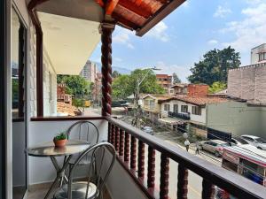 Un balcón con una mesa y vista a una calle. en Apartamento cerca a Estadio con balcon y 5 habitaciones, en Medellín