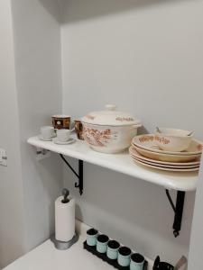 a white shelf with plates and bowls on it at Charming Studio for Two Persons in Rhardaïa +11 photos