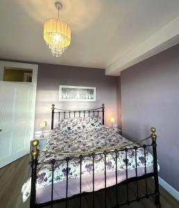 - une chambre avec un lit dans une pièce dotée d'un lustre dans l'établissement Cosy Apartment in Edinburgh city centre , 2 bedroom1 Bathroom, à Édimbourg