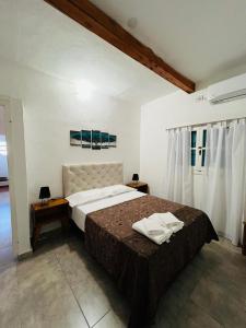 a bedroom with a large bed with towels on it at Villanto apart Solo Adultos in Mina Clavero