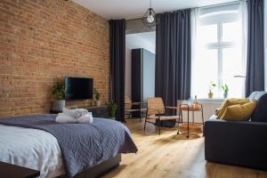 a bedroom with a bed and a brick wall at Soft Loft Apartamenty in Toruń
