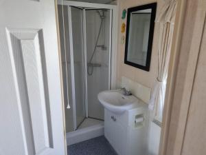 ML53 6 BERTH CARAVAN GOLDEN PALM CHAPET ST LEONARDs في شابيل سانت ليوناردز: حمام أبيض مع دش ومغسلة +3 صور