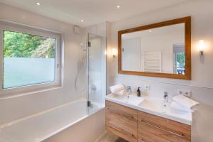 a bathroom with a sink and a shower and a mirror at Suite Werdenfels in Garmisch-Partenkirchen