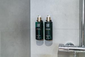 two green bottles on a wall next to a sink at Martini Hotel in Groningen +71 photos