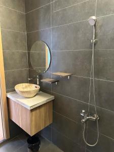 ein Badezimmer mit Waschbecken, Spiegel und Dusche in der Unterkunft Mary House in Buôn Ea Trum