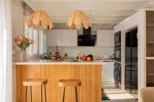 a kitchen with a counter and two stools at ELIVAAS House of Neptune - 3 BHK Cottage with Terrace & Gazebo on the Beach in Morjim