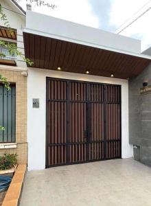 ein Haus mit einer Garage mit einer braunen Tür in der Unterkunft Mary House in Buôn Ea Trum