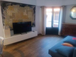 un salon avec une télévision à écran plat sur un meuble blanc dans l'établissement Vista al Castillo de Mora de Rubielos VUTE-22-036, à Mora de Rubielos