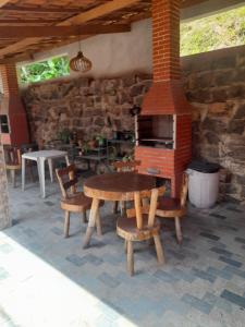a patio with a table and a brick oven at Chalés Monções in Ubatuba