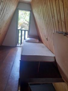 a bedroom with a bed in a room with a window at Chalés Monções in Ubatuba