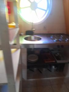 a kitchen with a sink and a clock on the wall at Chalés Monções in Ubatuba +75 photos