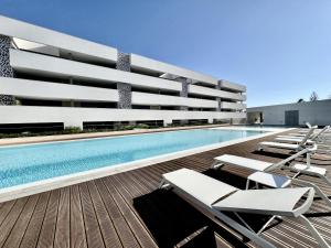 Lagos Prestige With Pool by Homing في لاغوس: مسبح مع كراسي جلوس على مبنى