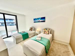 Lagos Prestige With Pool by Homing في لاغوس: سريرين في غرفة بها نافذة +43 صورة