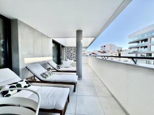 Lagos Prestige With Pool by Homing في لاغوس: شرفة مع أسرة وكراسي في مبنى